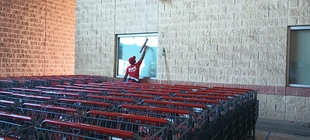window cleaner cleaning window of a grocery store