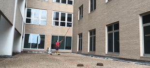 window cleaner using a pole to clean windows of a building